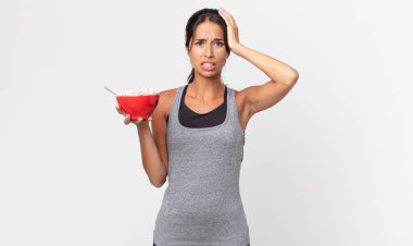 Genç İspanyol kadın stresli, endişeli ya da korkmuş hissediyor, elleri başının üstünde. Fitness diyeti ve kahvaltı konsepti