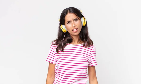 Młoda Latynoska Kobieta Czuje Się Zakłopotana Zdezorientowana Słuchając Muzyki Słuchawkami — Zdjęcie stockowe