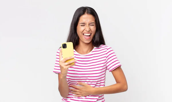 Молодая Латиноамериканка Громко Смеется Над Смешной Шуткой Держит Руках Смартфон — стоковое фото