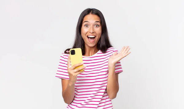 Young Hispanic Woman Feeling Happy Astonished Something Unbelievable Holding Smartphone — Stock Photo, Image