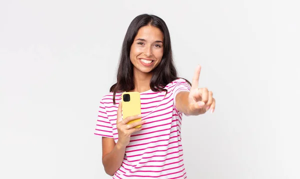 Jovem Hispânico Mulher Sorrindo Olhando Amigável Mostrando Número Segurando Smartphone — Fotografia de Stock