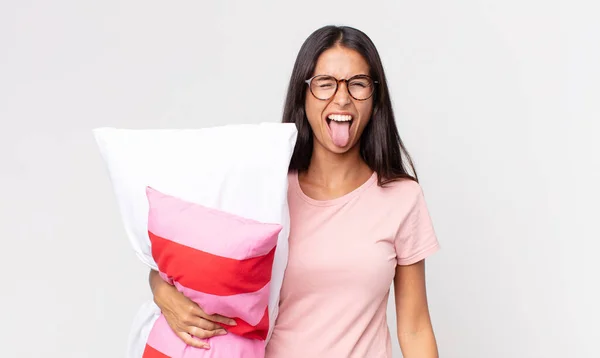 陽気で反抗的な態度の若いヒスパニック系の女性は パジャマを着て枕を持って外に舌を冗談と固執 — ストック写真