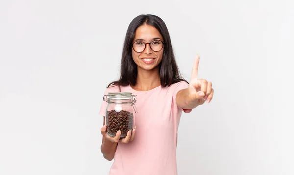 Giovane Donna Ispanica Sorridente Guardando Amichevole Mostrando Numero Uno Tenendo — Foto Stock