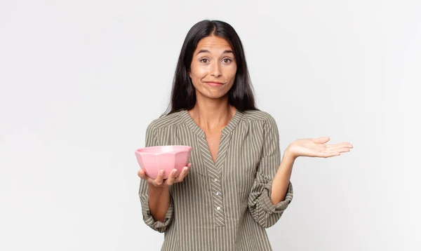 Young Hispanic Woman Feeling Puzzled Confused Doubting Holding Empty Bowl — Stock Photo, Image