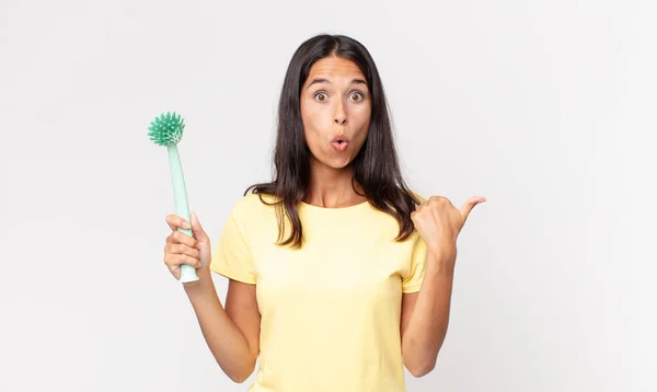 Jovem Hispânico Mulher Olhando Espantado Descrença Segurando Prato Escova Limpeza — Fotografia de Stock