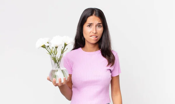 Молода Іспаномовна Жінка Виглядає Спантеличеною Збентеженою Тримаючи Декоративні Квіти — стокове фото