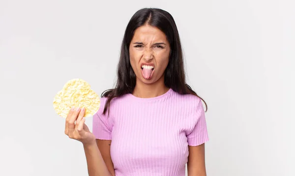 Молодая Латиноамериканка Чувствует Отвращение Раздражение Высунув Язык Держа Рисовое Печенье — стоковое фото
