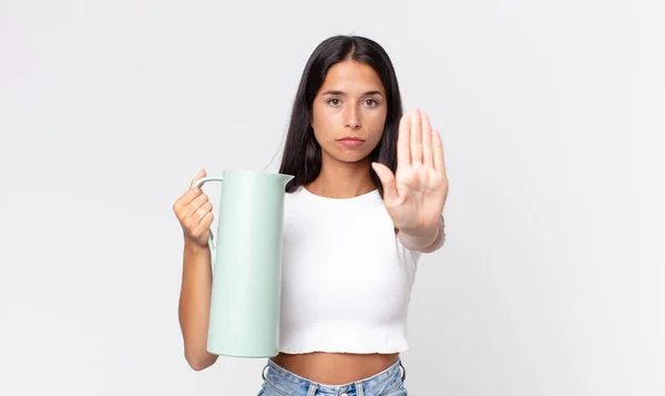 年轻的惊慌失措的女人看上去很严肃 露出张开的手掌 摆出停止姿势 拿着咖啡保温瓶 — 图库照片