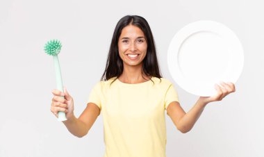 Güzel İspanyol kadın elinde temiz bir tabak tutuyor.