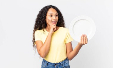 Güzel İspanyol kadın elinde temiz bir tabak tutuyor.