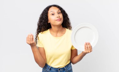 Güzel İspanyol kadın elinde temiz bir tabak tutuyor.