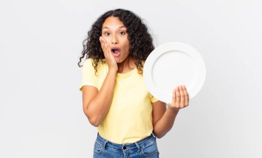 Güzel İspanyol kadın elinde temiz bir tabak tutuyor.