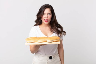 Güzel bir kadın şaşkın ve kafası karışmış hissediyor ve elinde ekmek tepsisi tutuyor.