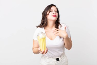 Güzel bir kadın stresli, endişeli, yorgun ve hayal kırıklığına uğramış ve elinde vanilyalı milkshake tutuyor.