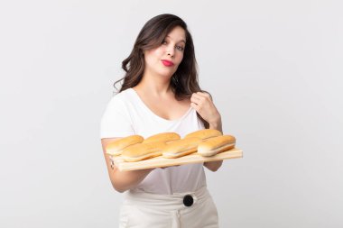 Güzel bir kadın kibirli, başarılı, pozitif ve gururlu görünüyor ve elinde ekmek tepsisi tutuyor.