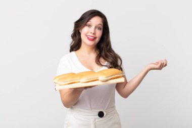 Güzel bir kadın kendini mutlu hisseder, bir çözüm ya da fikir bulduğunda şaşırır ve elinde bir ekmek tepsisi tutar.