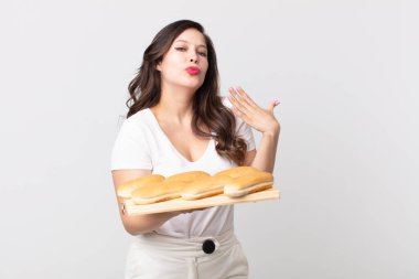 Güzel bir kadın stresli, endişeli, yorgun ve hayal kırıklığına uğramış hissediyor ve elinde ekmek tepsisi tutuyor.