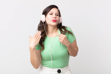 Güzel bir kadın stresli, endişeli, yorgun ve hayal kırıklığına uğramış kulaklıkla müzik dinliyor.