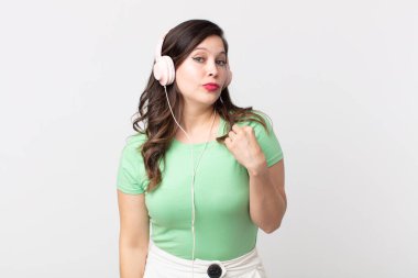 Güzel bir kadın kibirli, başarılı, pozitif ve gururlu görünüyor kulaklıkla müzik dinliyor.