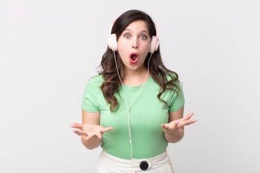 Güzel bir kadın kulaklıkla müzik dinlerken çok şaşırmış ve şok olmuş hissediyor.