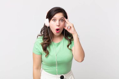 Güzel kadın şaşırmış görünüyor, kulaklıkla müzik dinleyen yeni bir düşünce, fikir ya da konsept fark ediyor.