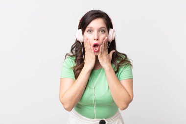 Güzel bir kadın şok olmuş ve korkmuş hissediyor kulaklıkla müzik dinliyor.