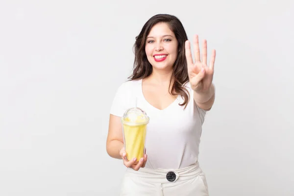 Bonita Mulher Sorrindo Olhando Amigável Mostrando Número Quatro Segurando Batido — Fotografia de Stock