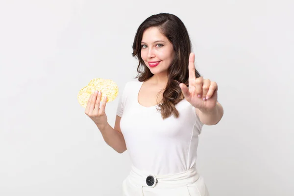 Bonita Mujer Sonriendo Orgullosa Confiadamente Haciendo Número Uno Sosteniendo Una — Foto de Stock