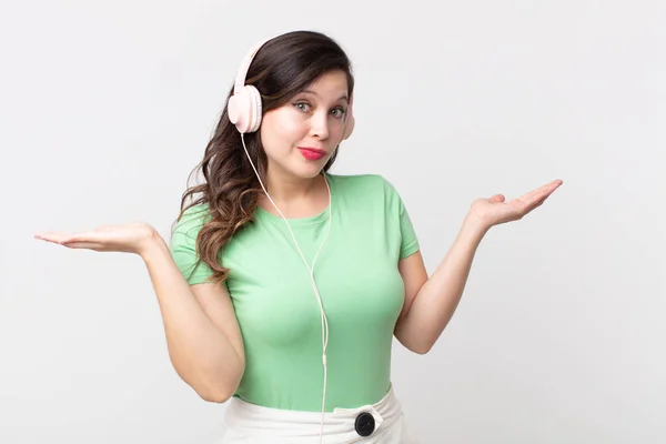 Bonita Mujer Sintiéndose Desconcertada Confundida Dudando Escuchar Música Con Auriculares — Foto de Stock