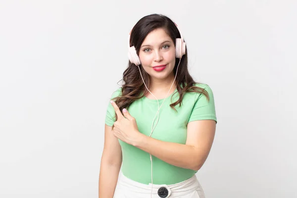 Bonita Mujer Sonriendo Alegremente Sintiéndose Feliz Señalando Lado Escuchando Música — Foto de Stock