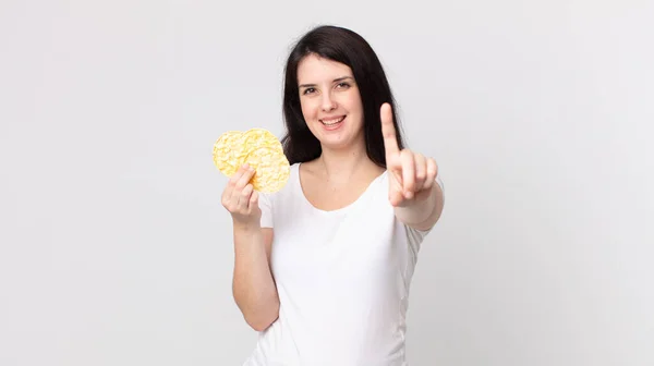 Bonita Mujer Sonriendo Orgullosa Confiadamente Haciendo Número Uno Sosteniendo Una — Foto de Stock