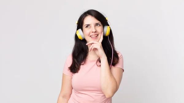 Mooie Vrouw Glimlachend Gelukkig Dagdromend Twijfelend Luistermuziek Met Hoofdtelefoon — Stockfoto