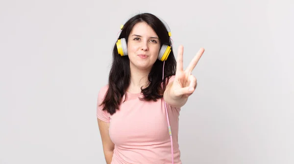 Mooie Vrouw Glimlachend Zoek Vriendelijk Tonen Nummer Twee Luisteren Muziek — Stockfoto