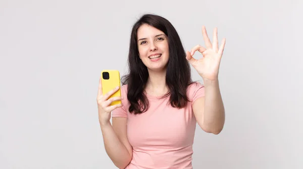 Симпатичная Женщина Чувствует Себя Счастливой Показывая Одобрение Жестом Помощью Смартфона — стоковое фото