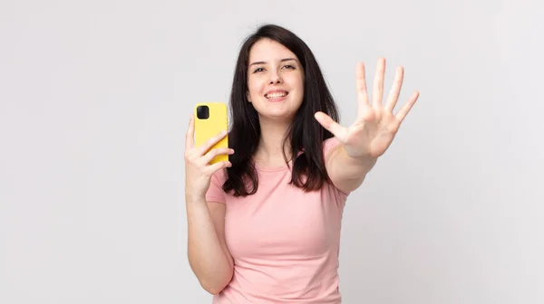 Mujer Bonita Sonriendo Buscando Amigable Mostrando Número Cinco Usando Teléfono — Foto de Stock