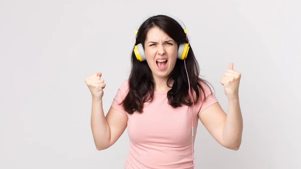 Ładna Kobieta Krzyczy Agresywnie Gniewnym Wyrazem Twarzy Słuchając Muzyki Słuchawkami — Zdjęcie stockowe