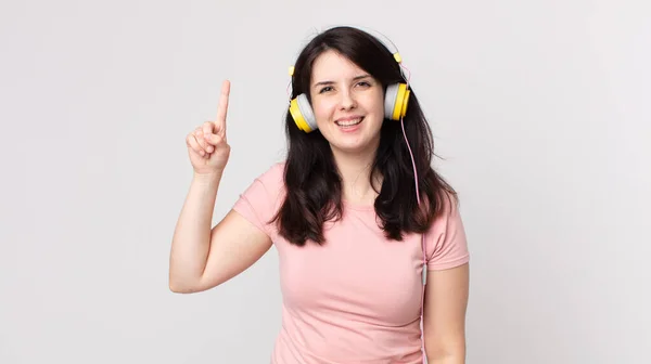 一个漂亮的女人在意识到用耳机听音乐的想法后 觉得自己是个快乐而又兴奋的天才 — 图库照片
