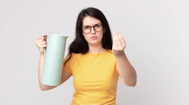 Güzel bir kadın kapiş ya da para hareketi yapıyor, sana ödemeni söylüyor ve elinde kahve termosu tutuyor.