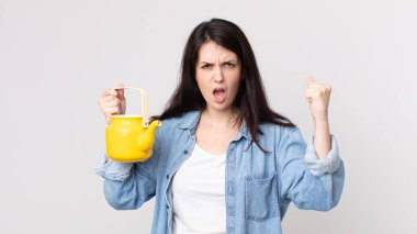 Güzel bir kadın sinirli bir ifadeyle bağırıyor ve elinde çaydanlıkla.