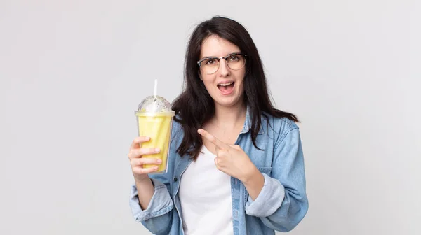 Bonita Mulher Olhando Animado Surpreso Apontando Para Lado Segurando Milkshake — Fotografia de Stock