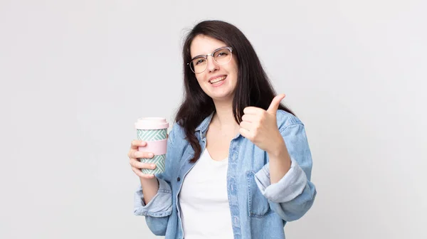 漂亮的女人感到自豪 微笑着竖起大拇指 端着一杯咖啡 — 图库照片
