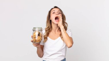 Oldukça zayıf bir kadın kendini mutlu hissediyordu. Elleri ağzının yanında ve elinde cam bir kurabiye şişesi tutarak bağırıyordu.