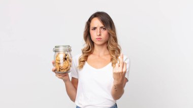 Oldukça zayıf bir kadın kızgın, sinirli, asi ve agresif hissediyor ve elinde cam bir kurabiye şişesi tutuyor.