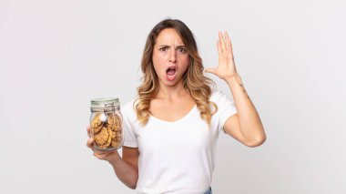 Elleri havada bağıran ve elinde cam bir kurabiye şişesi tutan oldukça zayıf bir kadın.