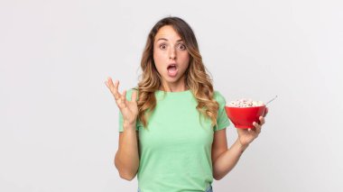 Oldukça zayıf bir kadın kendini mutlu ve şaşkın hissediyor. İnanılmaz bir şey ve elinde bir kahvaltı kasesi tutuyor.