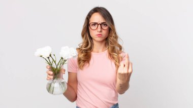 Oldukça zayıf bir kadın kızgın, sinirli, asi ve agresif ve elinde dekoratif çiçekler tutuyor.