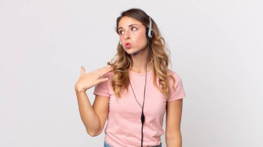 Oldukça zayıf bir kadın stresli, endişeli, yorgun ve hayal kırıklığına uğramış kulaklıklı bir operatör asistanı.