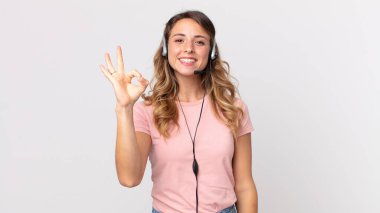 Oldukça zayıf bir kadın kendini mutlu hissediyor. Kulaklığı olan iyi bir jest operatörü asistanıyla onaylıyor.