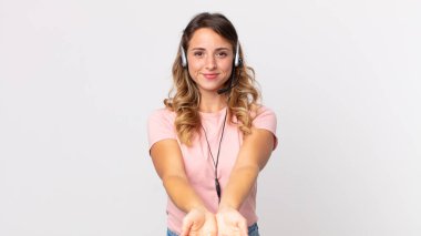 Oldukça zayıf bir kadın arkadaşça gülümsüyor ve öneriyor. Kulaklıklı bir konsept operatör asistanı.