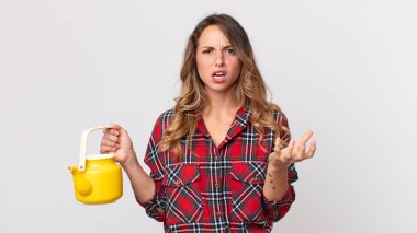 Oldukça zayıf bir kadın kızgın, sinirli ve hayal kırıklığına uğramış ve elinde çaydanlık tutan.